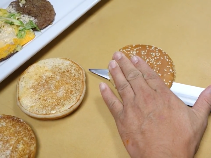 He then sliced each bun in half.