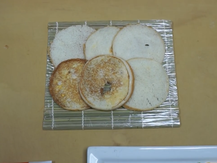 He then placed the halved buns onto a sushi mat.