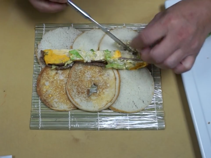 He cut up the remaining ingredients of the Big Mac and laid them out onto the bun slices.