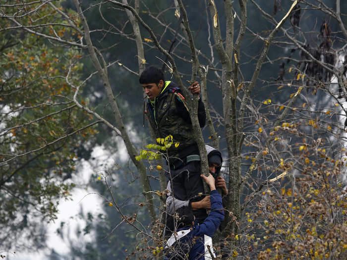 Migrants try to stop one of their group from attempting to hang himself during a demonstration, as they wait to cross the border from Greece into Macedonia, near Gevgelija, Macedonia.