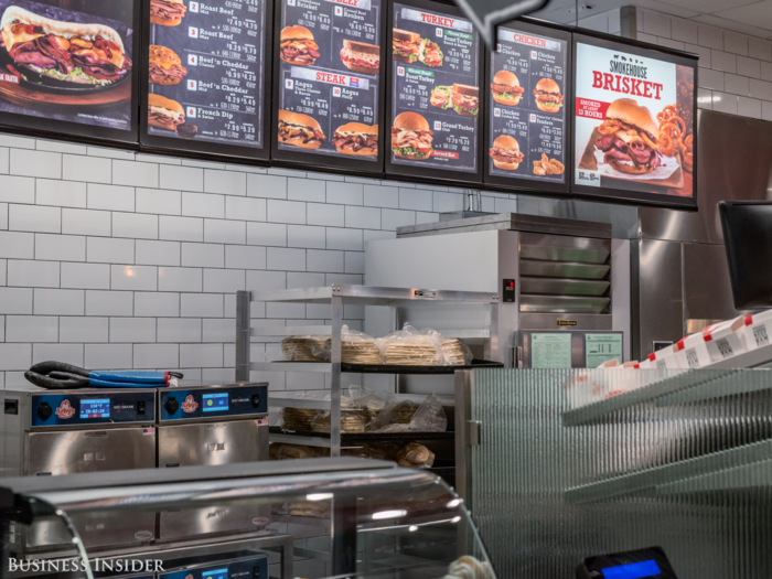 The new design features an open kitchen that allows customers to peek into the food prep area after they order and wait for their meal.