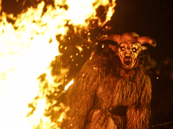 Most Krampuses have thick fur, sharp horns, cloven hooves, fangs, and a long, pointy tongue. They usually wear loud bells and chains, which they thrash around for effect, and carry a whip or birch branches to beat kids with.