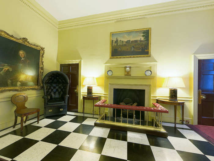 Through the door is the entrance hall. The black chair in the corner was initially used by guards who sat on watch outside, which is why it