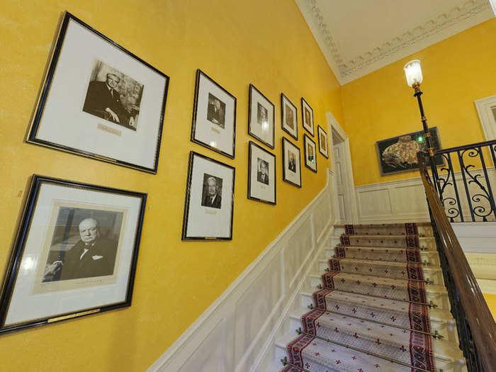 The walls are lined with portraits of past prime ministers, with the most recent incumbents at the top of the staircase. There