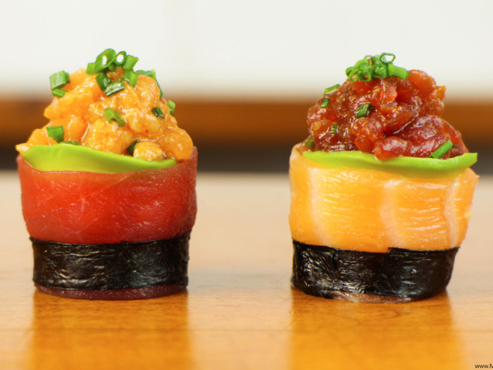 Instead of serving regular canapés at your next get-together, try these spicy tuna and salmon sushi canapés. The spicy tuna and salmon mixtures are nicely held in place by thin slices of avocado, sashimi, and nori.