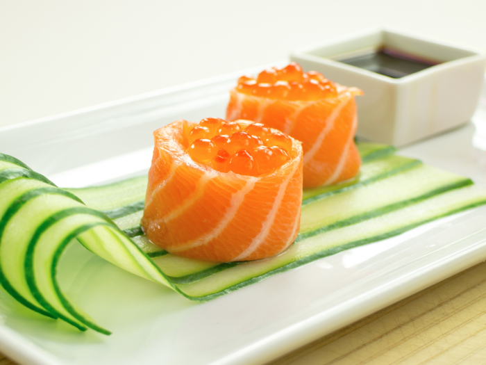 Made with thin slices of salmon and salmon roe, this battleship sushi roll is all about the cucumber garnish.