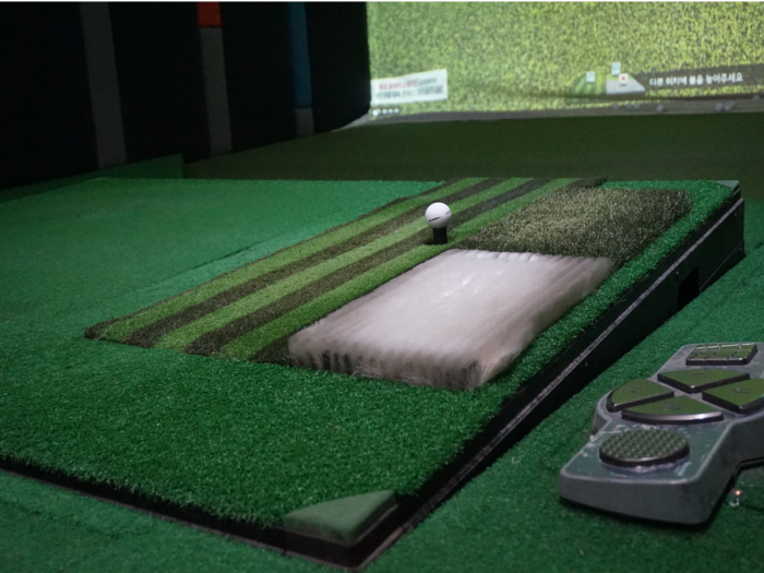 When you hit the bunker or rough, the stepping plate adjusts the angle accordingly. The white part of the plate is where you place the ball for bunker shots. It has special artificial grass, making it more difficult to hit.