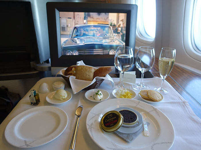 After we took off, the flight attendant came to refill my empty glass with even more Krug and served some warm nuts. He then took my lunch order. I first ordered the caviar, which came with a bread basket and way too many glasses. I was very impressed by the detailed plating. Instead of just scooping the caviar from the can, Cathay decided to bring out the can itself.