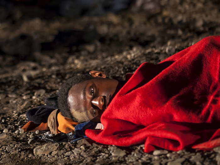 An African refugee rests after arriving on a fishing boat at Las Carpinteras beach in the Canary Island of Gran Canaria, Spain, September 1, 2015. Around 60 people, including six women and a two-year-old child, were aboard the fishing boat, according to local authorities.