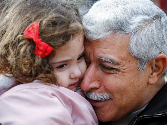 Hagop Manushian, a Syrian refugee who arrived earlier in the morning is reunited with his granddaughter Rita at the Armenian Community Centre of Toronto in Toronto, December 11, 2015.