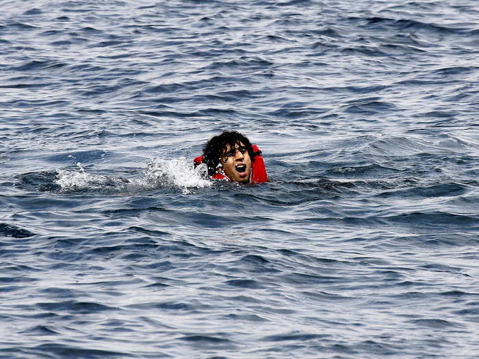 A Syrian refugee calls for help as he swims after jumping off an overcrowded dinghy while crossing a part of the Aegean Sea from Turkey to the Greek island of Lesbos September 23, 2015.