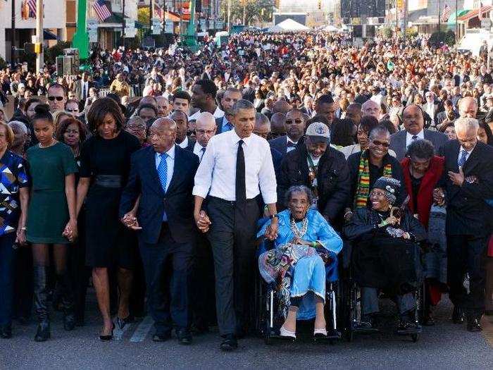 President Obama walks as he holds hands with Amelia Boynton Robinson, who was beaten during "Bloody Sunday," as they walk across the Edmund Pettus Bridge in Selma, Alabama for the 50th anniversary of “Bloody Sunday," a landmark event of the civil rights movement, Saturday, March 7, 2015.