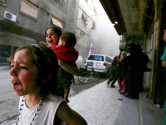 The war in Syria continued to grind on in 2015, with little end in sight. In this photo, Ghazal, 4, Judy, 7, carrying 8-month-old Suhair, react after what activists said was shelling by forces loyal to Syria