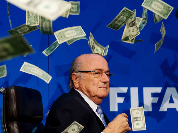 FIFA President Sepp Blatter resigns on June 2, 2015 in the wake of a corruption inquiry. In this photo, a comedian throws dollar bills at Blatter during a press conference.