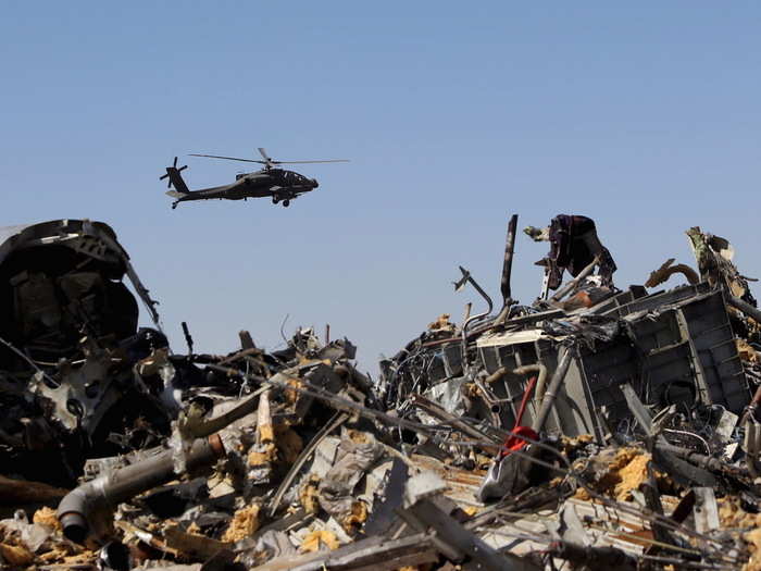 An Egyptian military helicopter flies over debris from a Russian airliner which crashed at the Hassana area in Arish city, north Egypt, November 1, 2015. The plane is thought to have been brought down by a bomb smuggled aboard by ISIS after it took off from Egypt