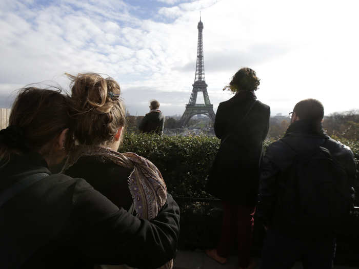 People observe a minute of silence at the Trocadero in front the Eiffel Tower to pay tribute to the victims of the series of deadly attacks on Friday in Paris on November 16, 2015.