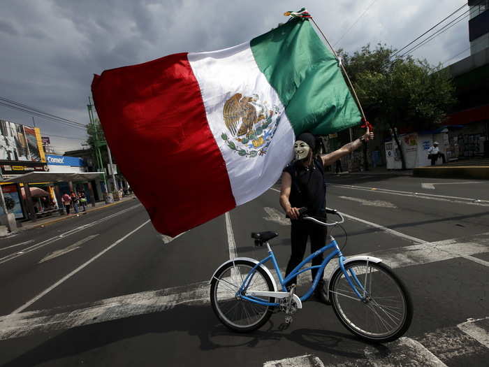 MEXCIO: A demonstrator wearing a Guy Fawkes mask holds up a Mexican flag during a protest to mark the eight-month anniversary of the Ayotzinapa students