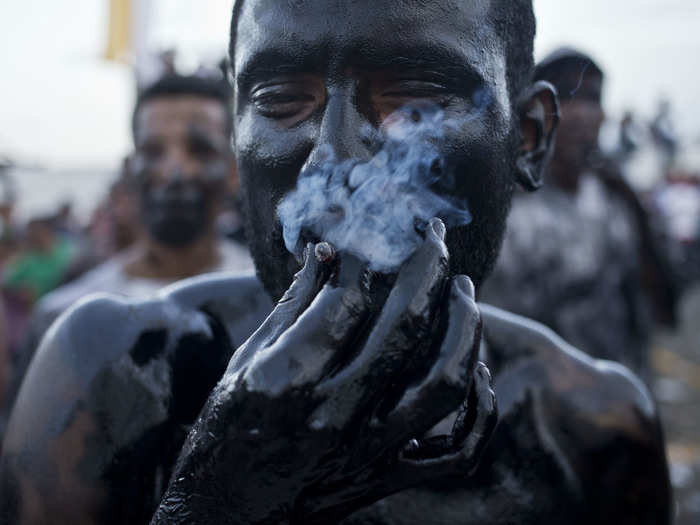 NICARAGUA: A man with his body coated in motor oil smokes a cigarette during the festivities in honor of Santo Domingo de Guzman in Managua, Nicaragua, Saturday, August 1, 2015.