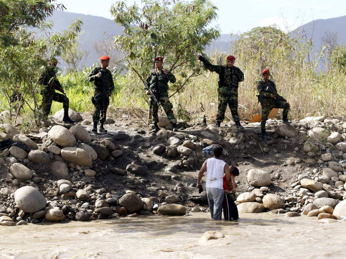 VENEZUELA: Venezuelan national guards deny the entry of a man and his son to Venezuela in the Tachira River, close to Villa del Rosario village, Colombia, August 26, 2015.