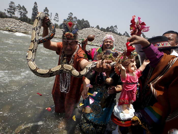 PERU: Peruvian shamans hold a figure of a Nino Jesus (child Jesus) and a snake while performing a ritual at the Rimac river on October 1, 2015. The ritual was aimed at fighting the negative effects of the Nino weather phenomena in Lima.