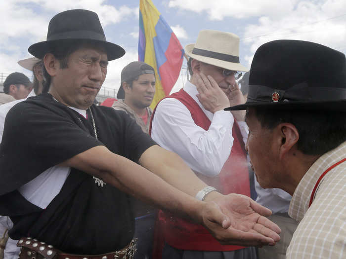 ECUADOR: A shaman spits a liquid on indigenous leader Salvador Quishe to cleanse him in Machachi, Ecuador, Tuesday, August 11, 2015, before the group travels to the capital. The indigenous group is going to Quito to join antigovernment protesters who have organized a national strike starting Thursday.