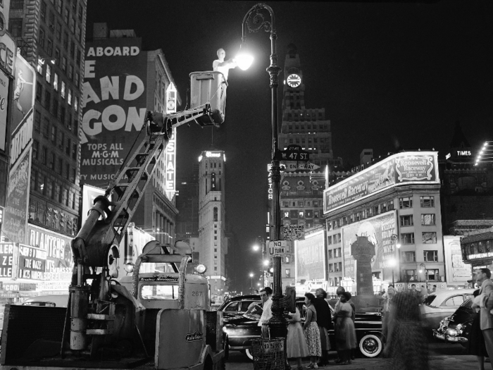 In the 1950s, Times Square was fully lit up. Here a Broadway Maintenance Corporation foreman replaced a burnt out light.