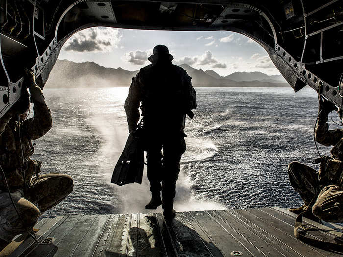 March 16: A U.S. Army Soldier with Operational Detachment Alpha 1215, 1st Special Forces Group, Joint Base Lewis-McChord, runs off the back of a CH-47F Chinook helicopter while conducting a simulated combat dive mission in the water off of Marine Corps Training Area Bellows. The helicopter hovered the ocean and allowed the Soldiers to conduct a boat movement leading to reconnaissance of the beach and a raid in the training facility at Bellows.