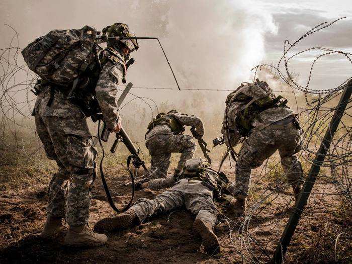 August 21: A U.S. Army Soldier, assigned to the Washington National Guard, uses his body to create an opening in a wire obstacle so his team can assault a position during Exercise Grizzly Defender, Alberta, Canada. Grizzly Defender is a joint training exercise with the Canadian Army Reserve with a focus on offensive tasks including patrols, convoys, raids, information operations, traffic control points, and company-level group attacks.