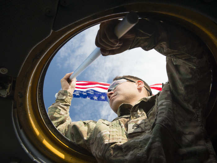 September 20: U.S. Army Staff Sgt. Brian Wright, 1st Battalion, 1st Special Operations Group (Airborne), holds a U.S. flag outside a C-130 Hercules during the 2015 Japanese-American Friendship Festival at Yokota Air Base, Japan. The U.S. flag, waved by Wright, was held out on one C-130 and a Japanese flag was simultaneously held outside another taxiing aircraft, symbolizing the U.S. and Japan partnership and reinforcing the general idea of the festival – to increase bilateral relationships between the two countries.