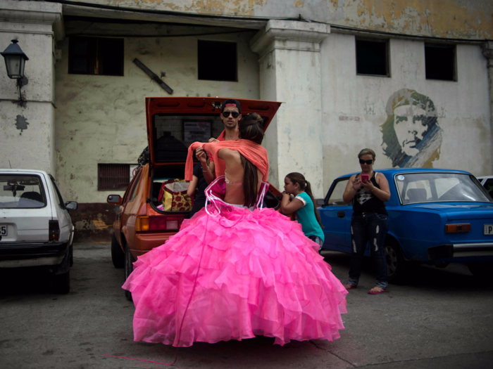 Quintana is seen changing from a traditional quinceañera dress into a more modern one. On the street is a mural of the Cuban revolutionary leader Ernesto "Che" Guevara.