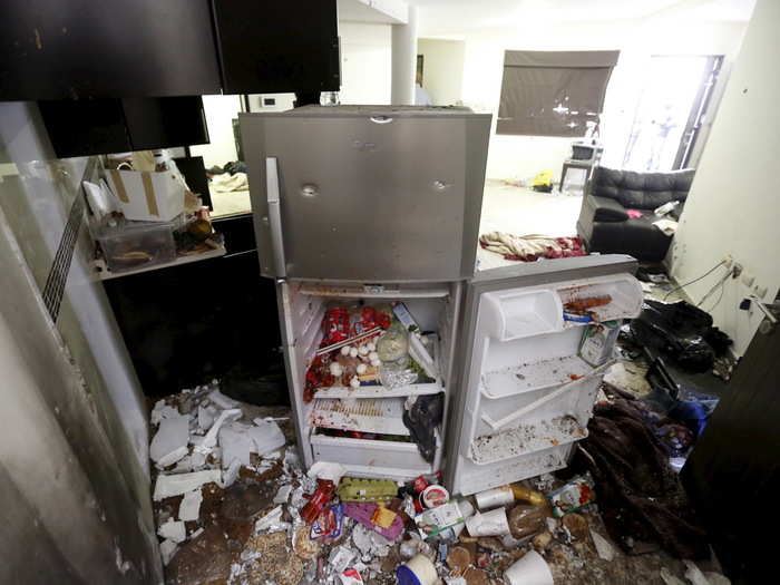 In this picture, the contents of a bullet-ridden fridge have poured out onto the floor of Guzmán