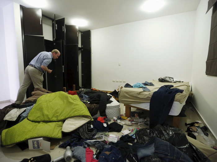 A journalist looks at belongings scattered across one of the hideouts