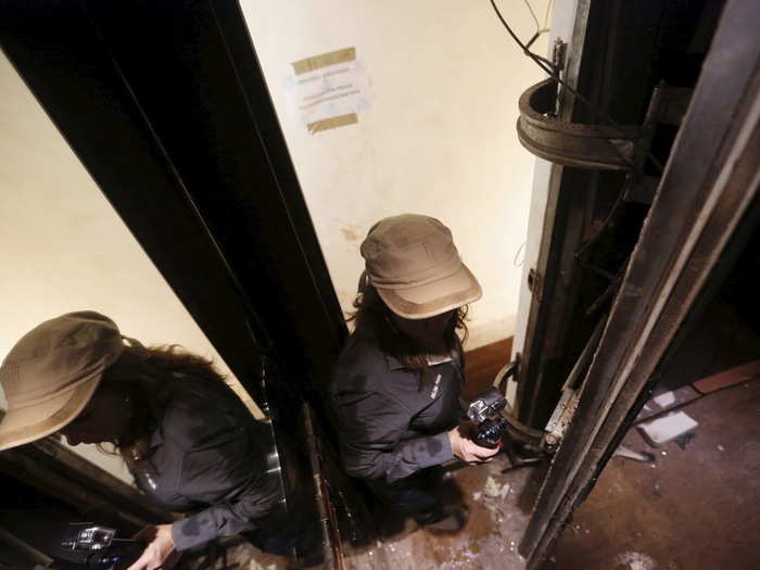 In this photo, a journalist slides behind the mirror into a secret passageway.