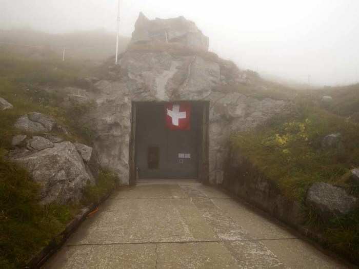 A flag flies in the fog over an entrance to the mountainous Sasso da Pigna fortress.