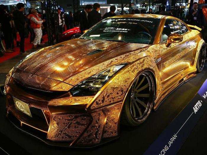 Here we see a Nissan R35 GT-R with intricate engravings and a custom paint job so it appears to be made out of gold.