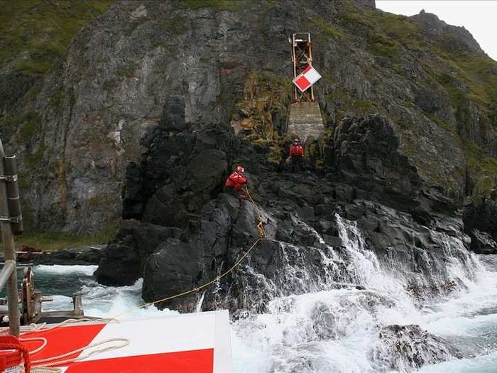 Here, Coat Guard crew members service a shore aid near Dutch Harbor.