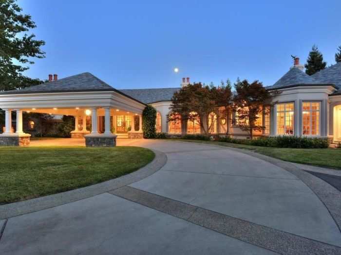 A circular driveway is protected by a full gated entrance, and the entire property has a security system. The garage has room for eight cars, and includes an electric-car hookup.