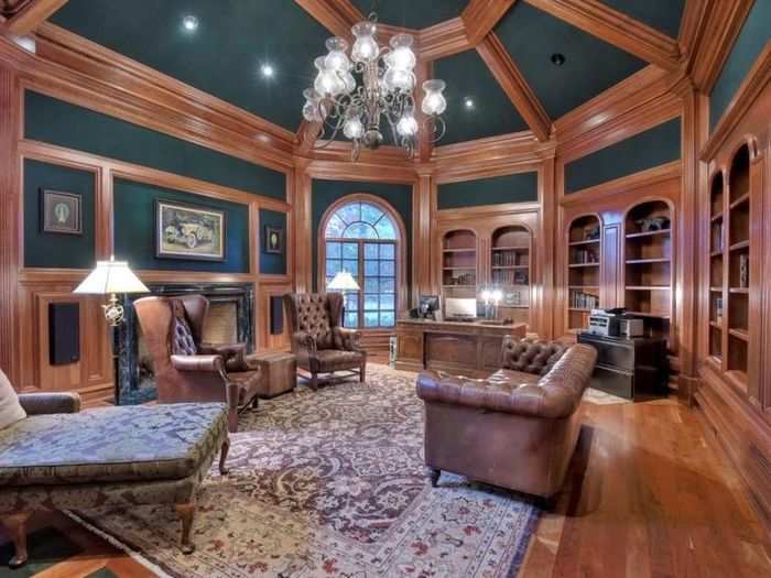 This library space is accented with wood paneling and an unusual teal wall color.