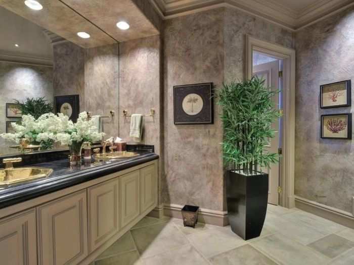 The bathroom is decked out in marble accents and a neutral color palette.