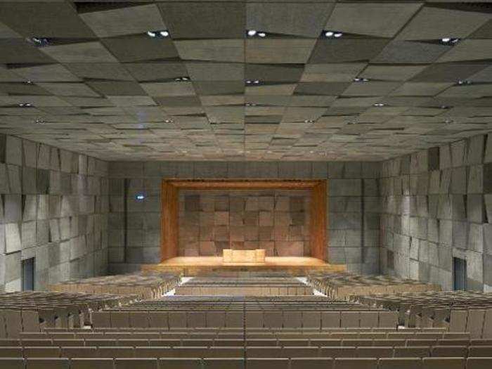 The motif even penetrates the auditorium, which has paneled gray walls and black and white seats.