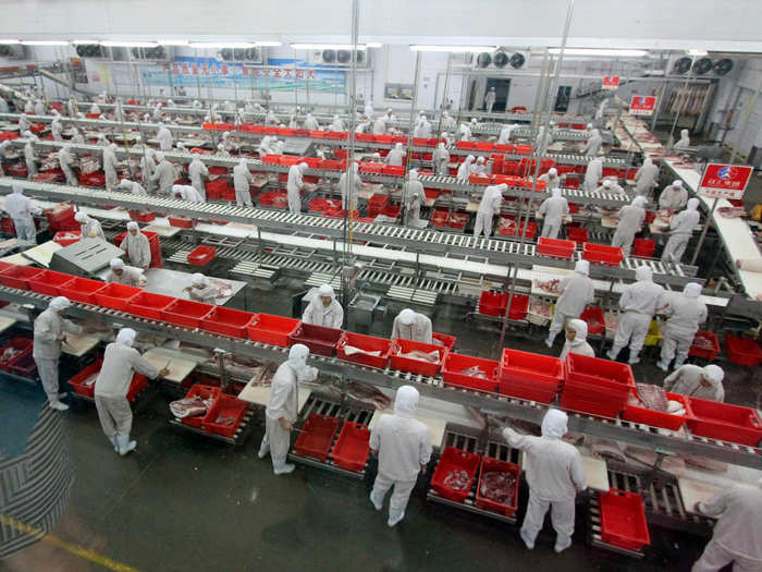 A factory line of employees process meat at a factory in Luohe, Henan province.