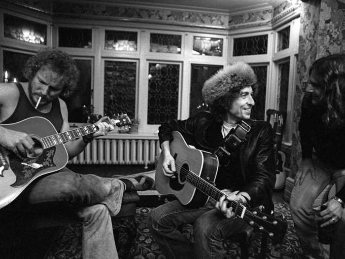 Here, Dylan plays at the home of folk singer Gordon Lightfoot (left) with Roger McGuinn (right).