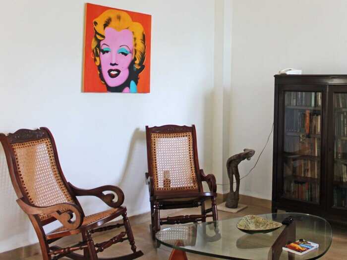 Bienvenidos a nuestra casa aquí en Habana, Cuba! This is what our living room looked like. We had two wooden rocking chairs, a glass table, and a bookcase. Most of the furniture in our apartment, including the Marilyn Monroe canvas, was from IKEA.