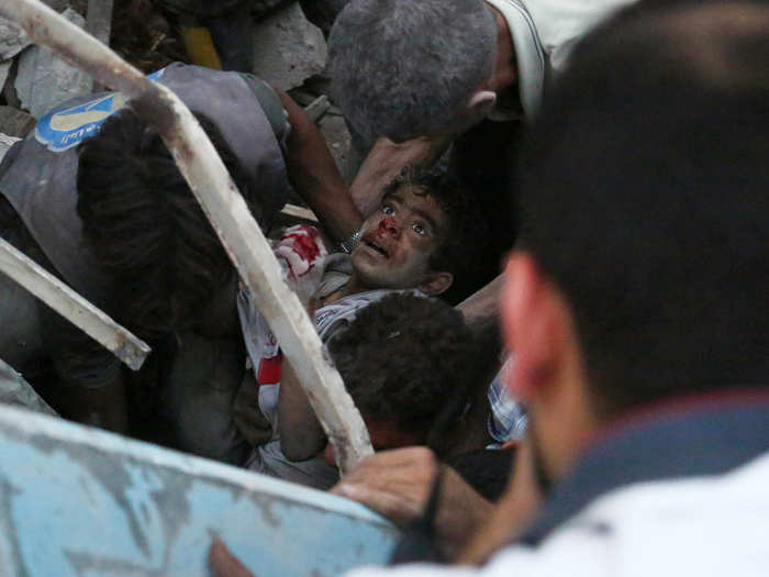 Spot News Stories, 1st prize: Sameer Al-Doumy, Syria — Aftermath of airstrikes in Syria. A boy is evacuated from rubble following reported airstrikes in the city of Douma, Syria, 16 June 2015.