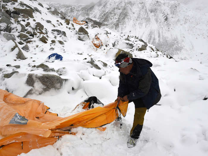 Spot News Stories, 2nd prize: Roberto Schmidt, Germany — Trekking guide Pasang Sherpa searches for survivors among flattered tents moments after a wall of rock, snow and debris slammed on Everest Base camp. Nepal, 25 April 2015.