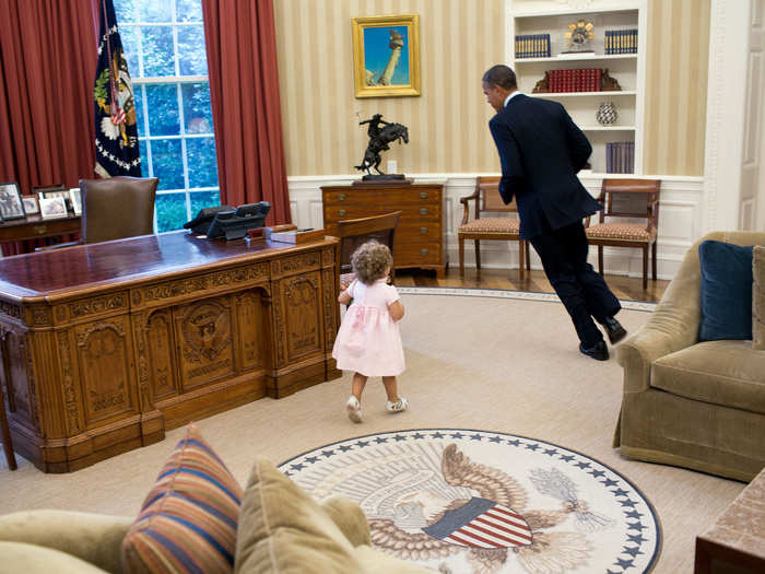 Obama circles his desk with a petite pink pal in hot pursuit.