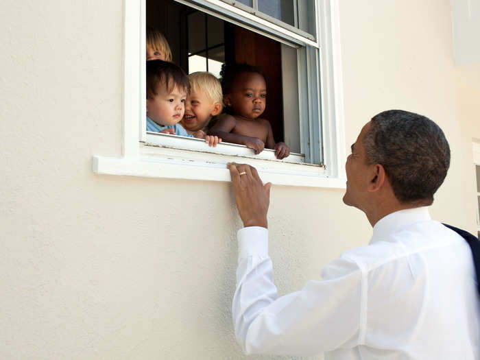 Skeptical infants peer at the POTUS through a window.