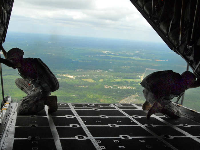 US Army Master Sgt. Dwight Simon and Staff Sgt. Monte Henderson watch for the drop zone from the ramp of a C-130