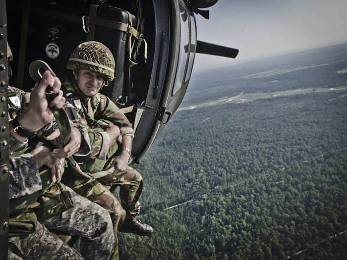 British Colour Sgt. Christopher Wright (Far Right) gets ready to jump onto St. Mere Eglise drop zone from a UH-60 Black Hawk at Fort Bragg while training with US Army paratroopers.