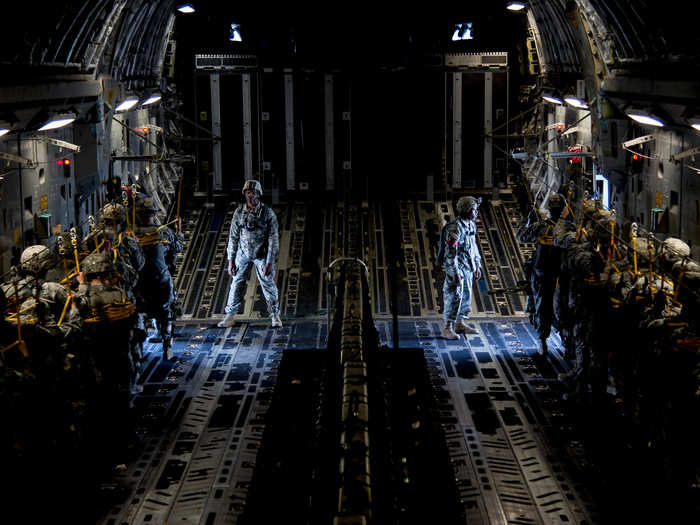 US Army paratroopers on a C-17 Globemaster III wait for the green light indicating it is time to jump.